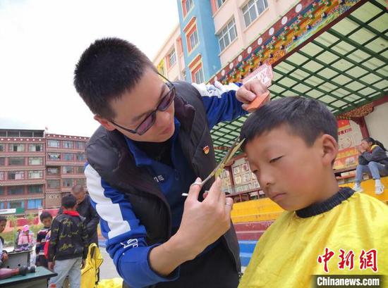 Volunteer teachers is cutting a student's hair. (Photo: China News Service/Liu Xiaoyi) Volunteer teachers is cutting a student's hair. (Photo: China News Service/Liu Xiaoyi)